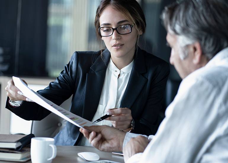 Young female lawyer working on contracts with businessman