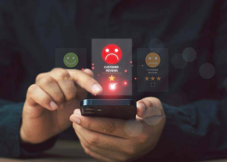 customer posting a sad face emoji on an online review from their mobile