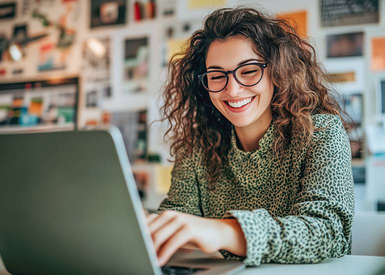 confident smiling woman using laptop - symbolising business tech
