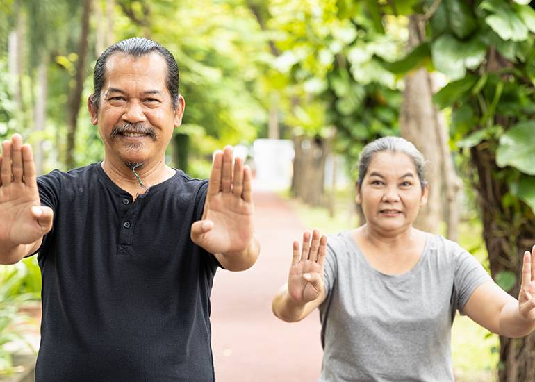 strong elderly man and woman showing resilience doing tai chi