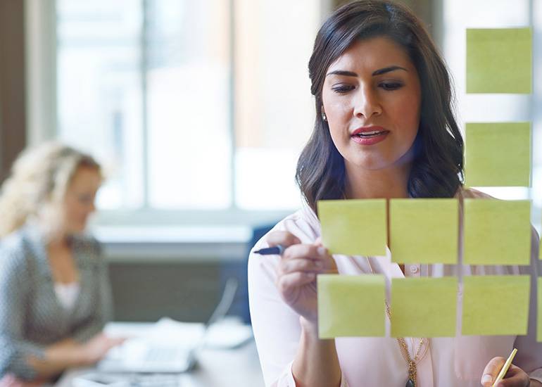 motivation goal setting - woman writes on post-it notes